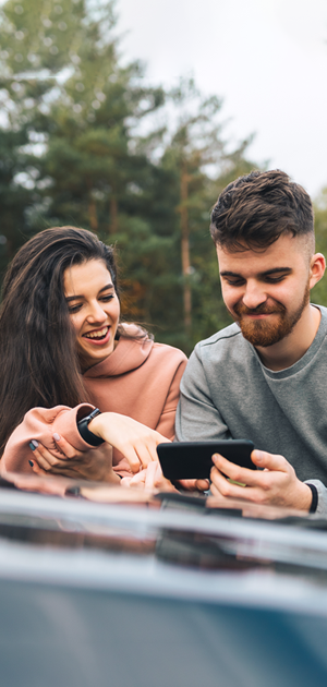 Coppia di ragazzi che guardano un video sullo smartphone all'aperto